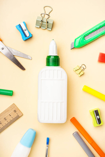 Composition with bottle of glue and different stationery on color background - Photo, Image