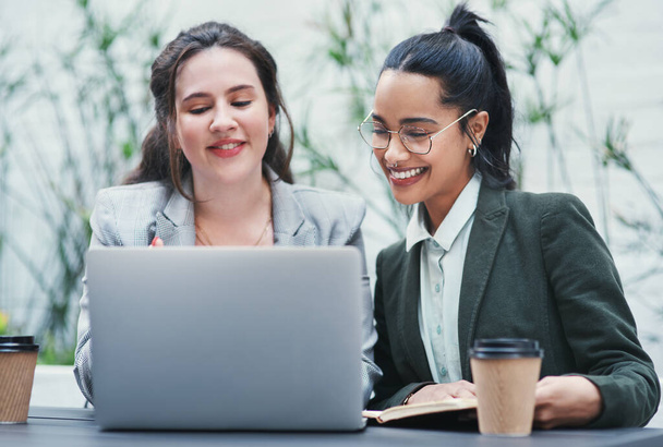 Успех бизнеса начинается и заканчивается совместной работой. две молодые деловые женщины за ноутбуком во время встречи в кофейне - Фото, изображение