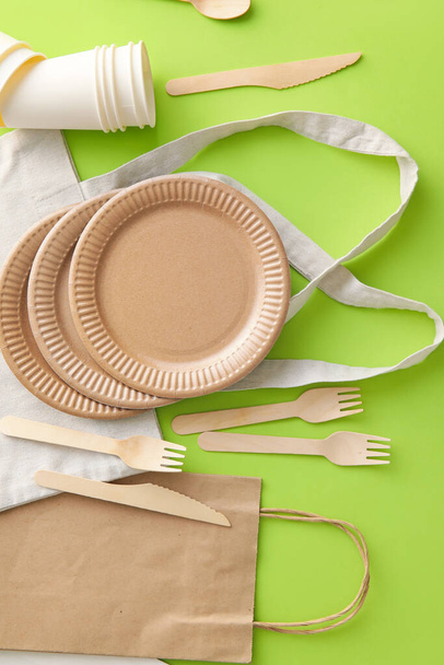 Different bags and Eco tableware on green background - Photo, Image