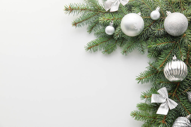 白地に銀色のクリスマス飾りのあるモミの木の枝 - 写真・画像