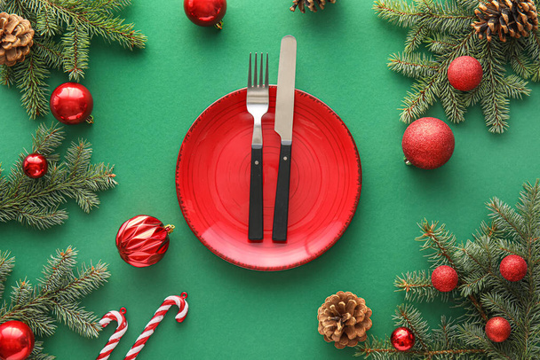 Schöne Tischdekoration mit Tannenzweigen und Weihnachtsdekoration auf grünem Hintergrund - Foto, Bild
