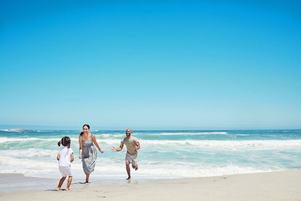 Пляж, біг і щаслива сім'я з дитиною з тропічним морем, острівний відпочинок або подорожі відпочинок блакитне небо глузують з реклами. Здоровий, енергія та зв'язок матері, батька та дівчинки на піску та океані
. - Фото, зображення