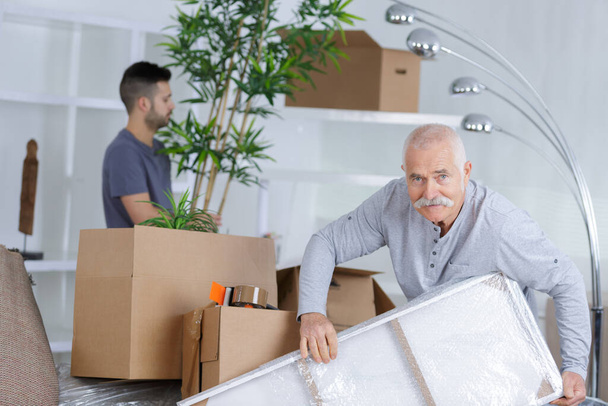 grandson helping his grandfather moving - 写真・画像