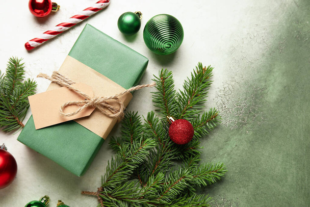 Komposition mit Weihnachtsgeschenk, Dekorationen und Tannenzweigen auf Grunge-Hintergrund - Foto, Bild