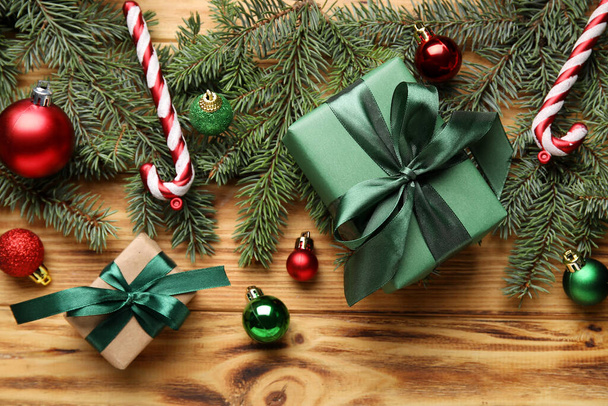 Složení s jedlovými větvemi, vánoční dárky a dekorace na dřevěném pozadí, detailní záběr - Fotografie, Obrázek
