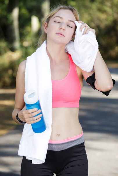 female jogger wiping her brow with a towel - Foto, Bild