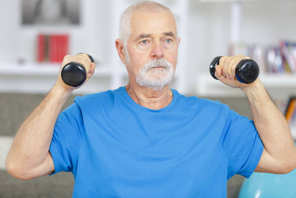 senior male with dumbells at home - Photo, Image