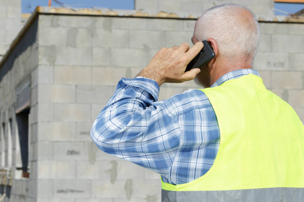 senior builder on the phone outdoors construction - Zdjęcie, obraz