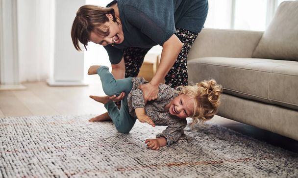 Vas a dar un paseo. una atractiva madre joven y jugando con su hija en la sala de estar en casa - Foto, imagen