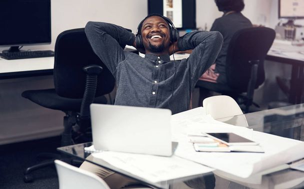 Tan feliz como un arquitecto puede ser. un apuesto joven arquitecto masculino sonriendo sentado con las manos detrás de la cabeza en una oficina moderna - Foto, imagen