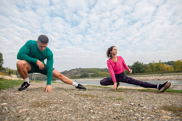 Incredibile coppia sta allungando le gambe e il riscaldamento insieme prima del loro allenamento - Foto, immagini