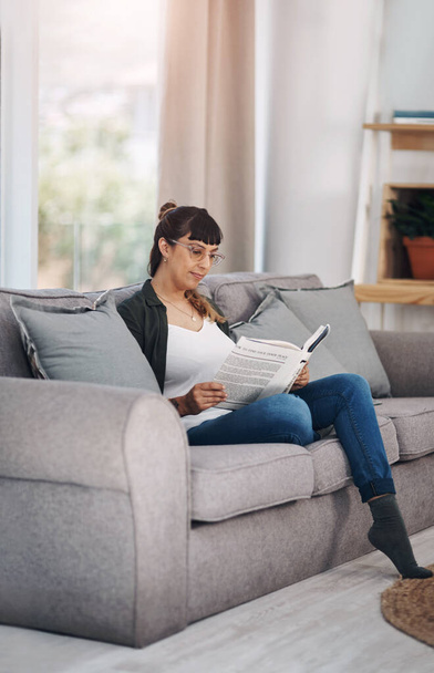 Jen já, já a dobrá kniha. Plná délka záběr atraktivní mladé ženy sedí sám ve svém obývacím pokoji a čtení knihy - Fotografie, Obrázek