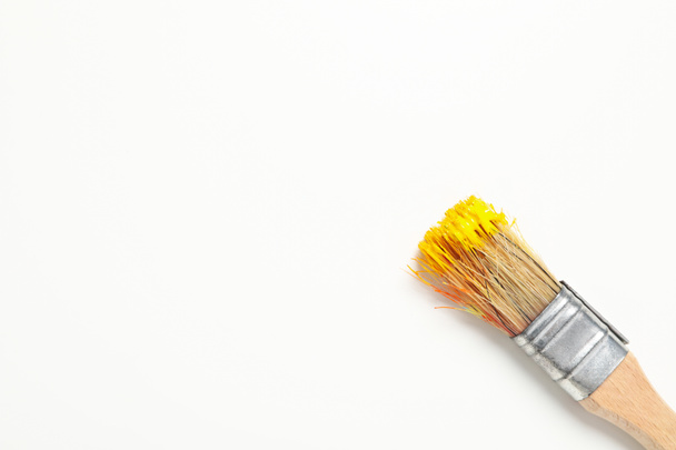Paint brush with yellow paint on white background - Foto, Imagen