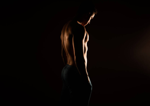 Silueta de músculos de un hombre guapo parado en el estudio - Foto, Imagen