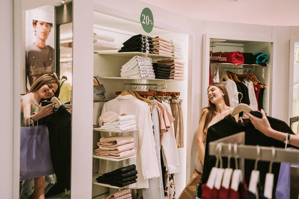 Две красивые девушки веселятся в магазине мод в торговом центре - Фото, изображение