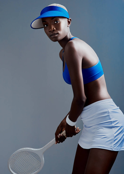 I hope youre ready for this. Studio shot of a sporty young woman posing with a tennis racket against a grey background - Foto, imagen