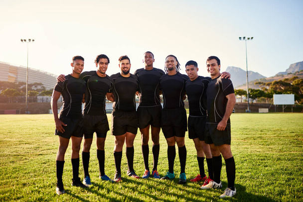 Мы разделяем взаимную любовь к спорту. Полный портрет разнообразной группы спортсменов, стоящих вместе перед игрой в регби в течение дня - Фото, изображение