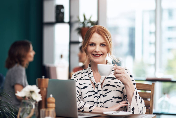 Heres to a successful day. Portrait of an attractive middle aged woman having a cup of coffee inside of a coffee shop during the day - Foto, Bild