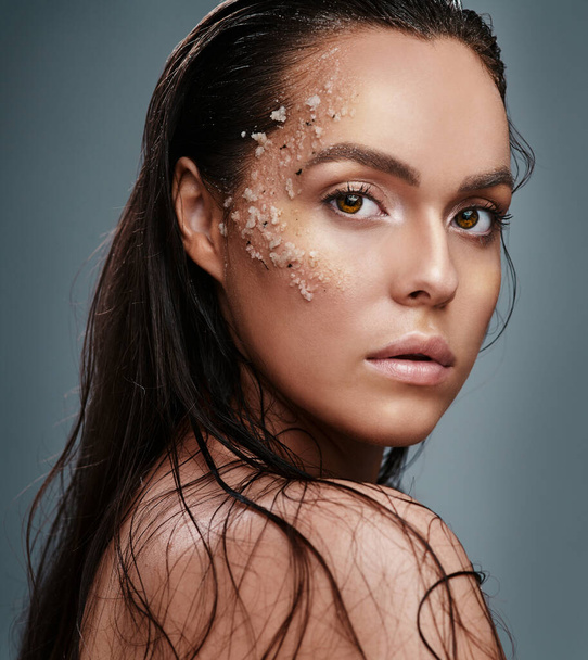 Lets talk about the importance of exfoliating. a beautiful young woman posing with salt on her face - Photo, Image