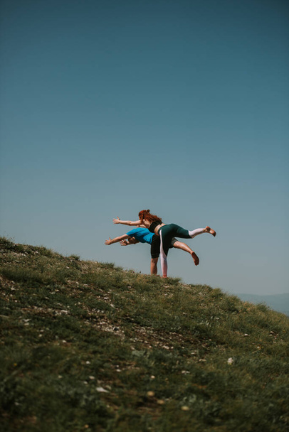 Partner di yoga fare alcune pose yoga sulla cima della montagna - Foto, immagini