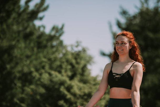 Close up of beautiful yoga girl with red curly hair smiling - Foto, afbeelding