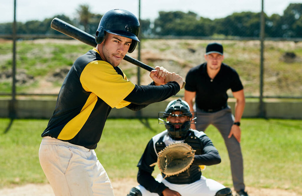 Il sait utiliser une batte comme un pro. un beau jeune joueur de baseball se préparant à frapper une balle lors d'un match sur le terrain - Photo, image
