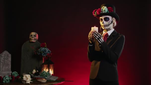 Žena s lebkou si vymyslela sfouknutí hořící svíčky ve studiu, převlečená za bohyni smrti, aby oslavila dios de los muertos. Uhasit plamen a chovat se děsivě na tradičním Halloweenu. - Záběry, video