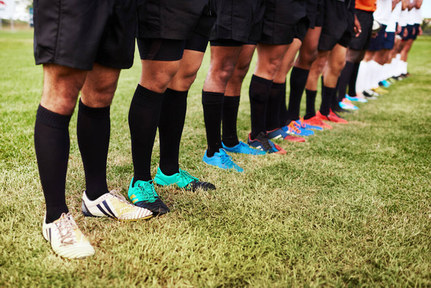 Poniendo todo en juego. un grupo de jugadores de rugby de pie juntos en una línea en el campo - Foto, Imagen