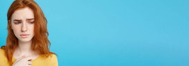Kopfballporträt eines zarten rothaarigen Teenagers mit ernstem Gesichtsausdruck, der in die Kamera blickt. kaukasische Frau Modell mit Ingwerhaaren posiert indoors.pastellblauer Hintergrund. Kopierraum - Foto, Bild