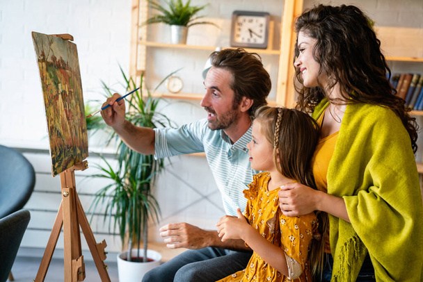 Happy family concept. Young smiling parents with children painting together at home. People fun happiness. - Fotografie, Obrázek