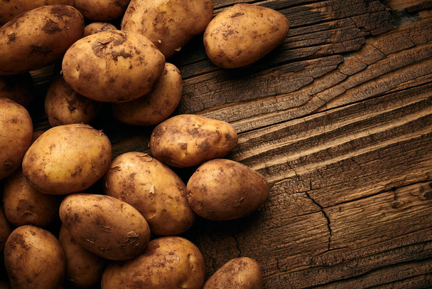 Patatesler ahşap zeminde. Eski yemekler hala hayat dolu. - Fotoğraf, Görsel
