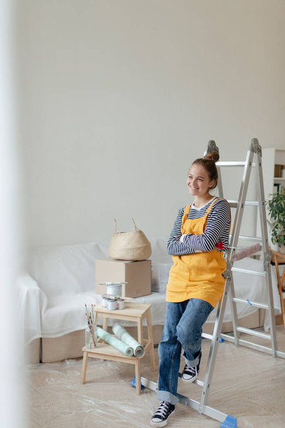 Glückliche junge Frau macht Pause bei Renovierung ihres Hauses. - Foto, Bild