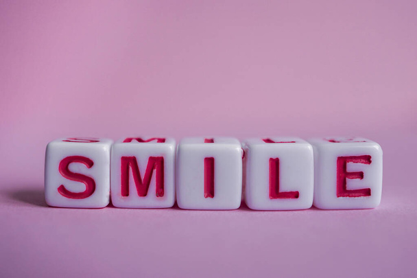 glimlach woord met rode kubus letters, gevoelens en emoties  - Foto, afbeelding
