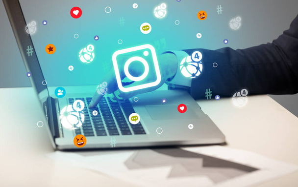 Hand surfing on the social media with camera icons coming out from the screen, networking concept - Foto, imagen