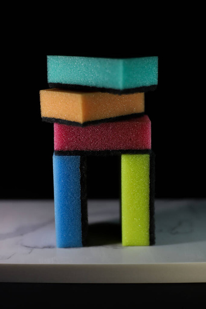 kitchen sponges of different colors on a black background for advertising banners labels flyers - Foto, afbeelding