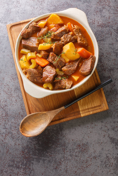 Irish Stew Stobhach ist ein Eintopf aus Irland, der traditionell mit Wurzelgemüse und Fleisch in Nahaufnahme im Topf auf dem Tisch zubereitet wird. Vertikale Ansicht von oben - Foto, Bild