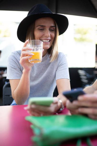 Muotokuva nainen istuu kahvilapöydässä matkapuhelimella - Valokuva, kuva