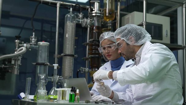 Двоє вчених у професійній уніформі працюють в лабораторії хіміко біомедичного експерименту
 - Фото, зображення