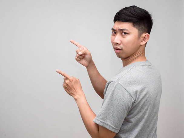 asiático hombre gris camisa confundido vuelta alrededor gesto punto dedo aislado - Foto, Imagen