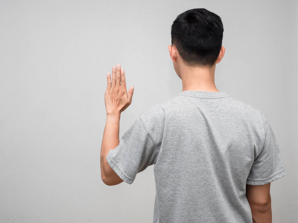 Behind of man grey shirt standing show hand to stop isolated - Photo, Image