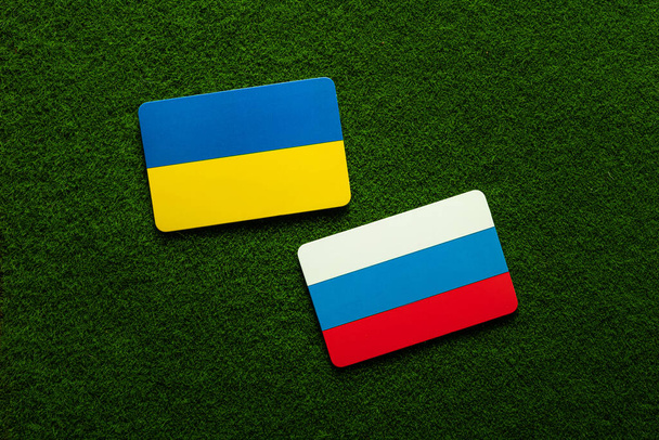 Ucrania vs Rusia. Banderas de símbolo sobre un fondo de césped verde. Guerra. Hablando. Relación. Vista superior. - Foto, Imagen