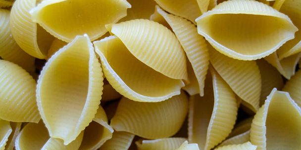 pasta Conchiglioni close-up. yellow pasta. pasta texture. Horizontal image. Banner for insertion into site. - Fotoğraf, Görsel