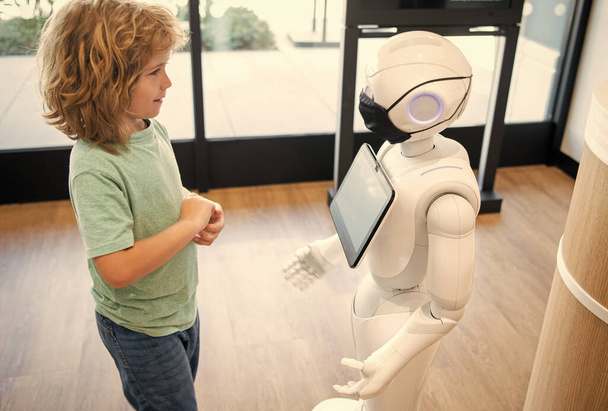 μικρό αγόρι αλληλεπιδρούν με ρομπότ τεχνητή νοημοσύνη, αλληλεπίδραση. - Φωτογραφία, εικόνα