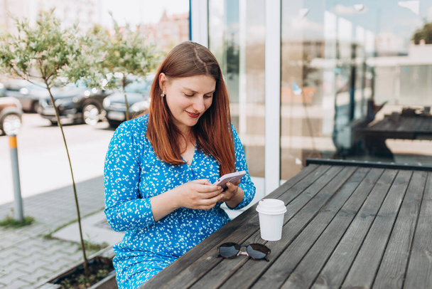 Γυναίκα που χρησιμοποιεί smartphone στην Ευρωπαϊκή πόλη. Χίππη κορίτσι περιήγηση στο Internet σε ένα τηλέφωνο, μηνύματα και επικοινωνία σε εξωτερικούς χώρους. Σχέδιο ταξιδίου - Φωτογραφία, εικόνα