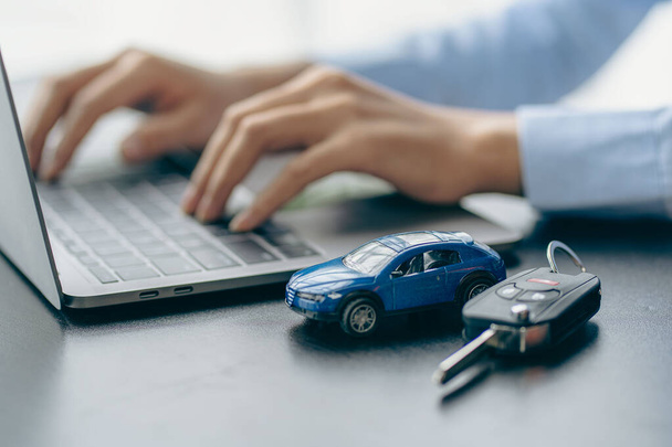 Car rental sales concept, Asian businesswoman working with toy cars on the table. Concepts of cars, property, ownership, insurance and transportation. - Photo, Image