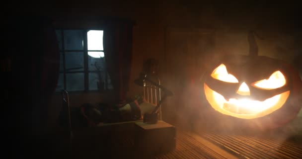 Horror Halloween concept. Creepy abandoned castle. An old candlestick and Halloween pumpkin glowing on wooden stairs with lattice door at night. Decoration with backlight and fog. Selective focus - Footage, Video