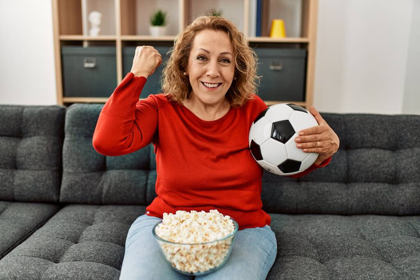 Middle age caucasian soccer fan smiling happy watching football game at home. - Foto, Bild
