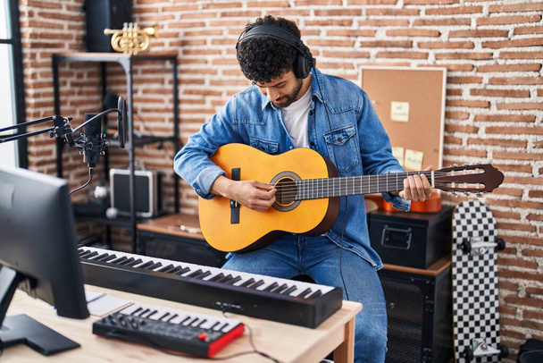 Giovane musicista arabo che suona la chitarra classica in studio di musica - Foto, immagini