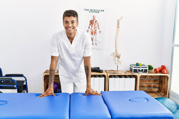 Jeune homme hispanique travaillant comme physiothérapeute à la salle de physiothérapie - Photo, image