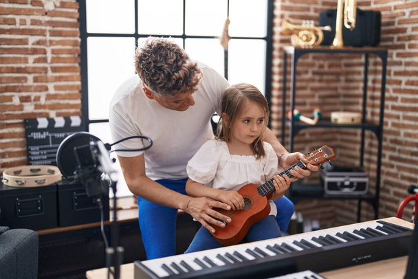 Πατέρας και κόρη παίζουν γιουκαλίλι στο στούντιο μουσικής - Φωτογραφία, εικόνα